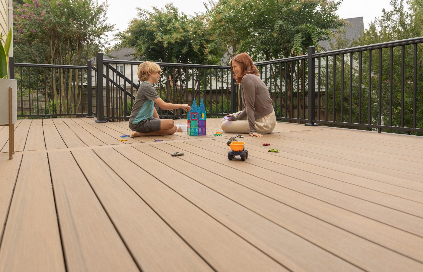 A person and a child playing with toys on a deck
Description automatically generated